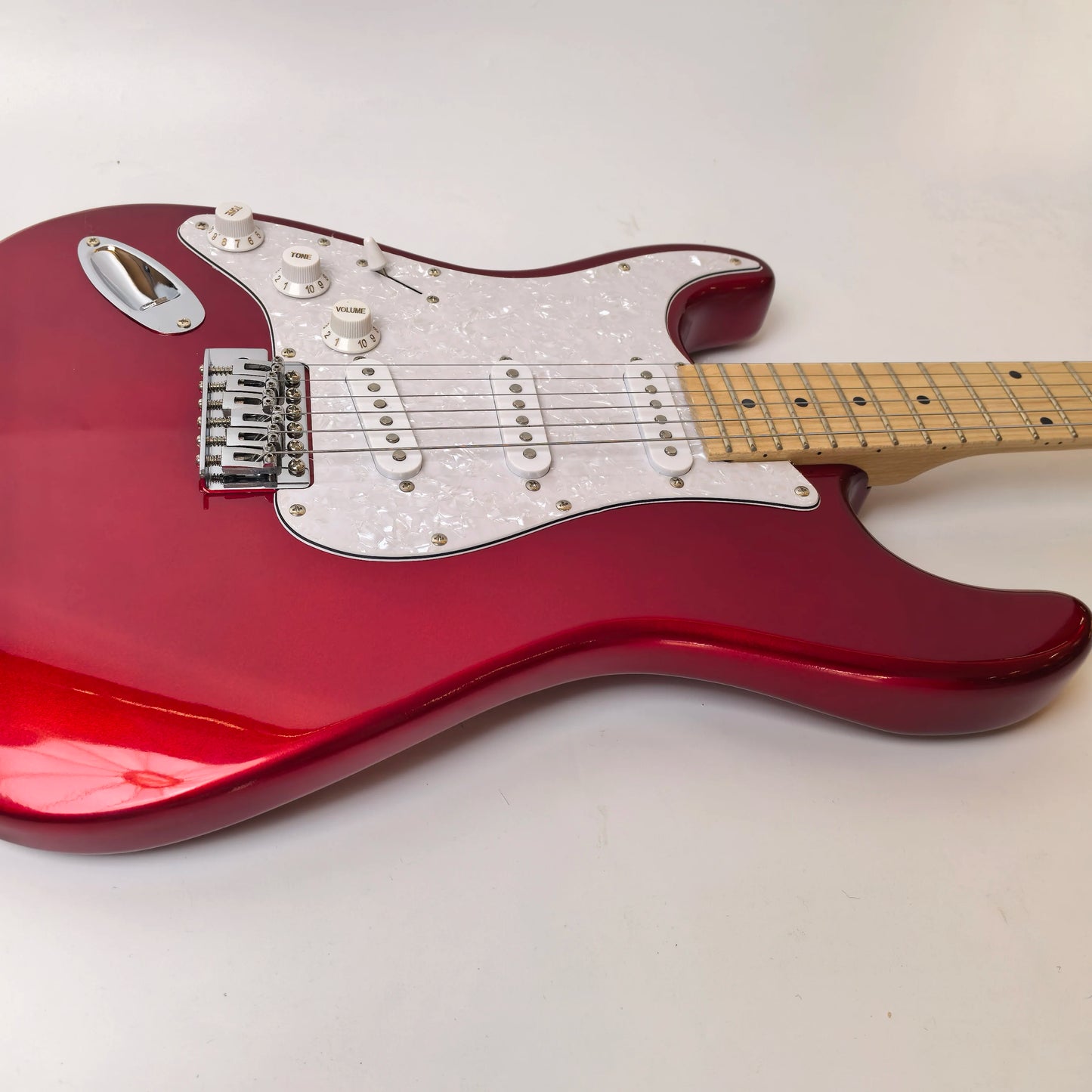 In stock, left-handed 6-string electric guitar in metallic red, made of mahogany with pearl pickguard. Ready to ship upon order!