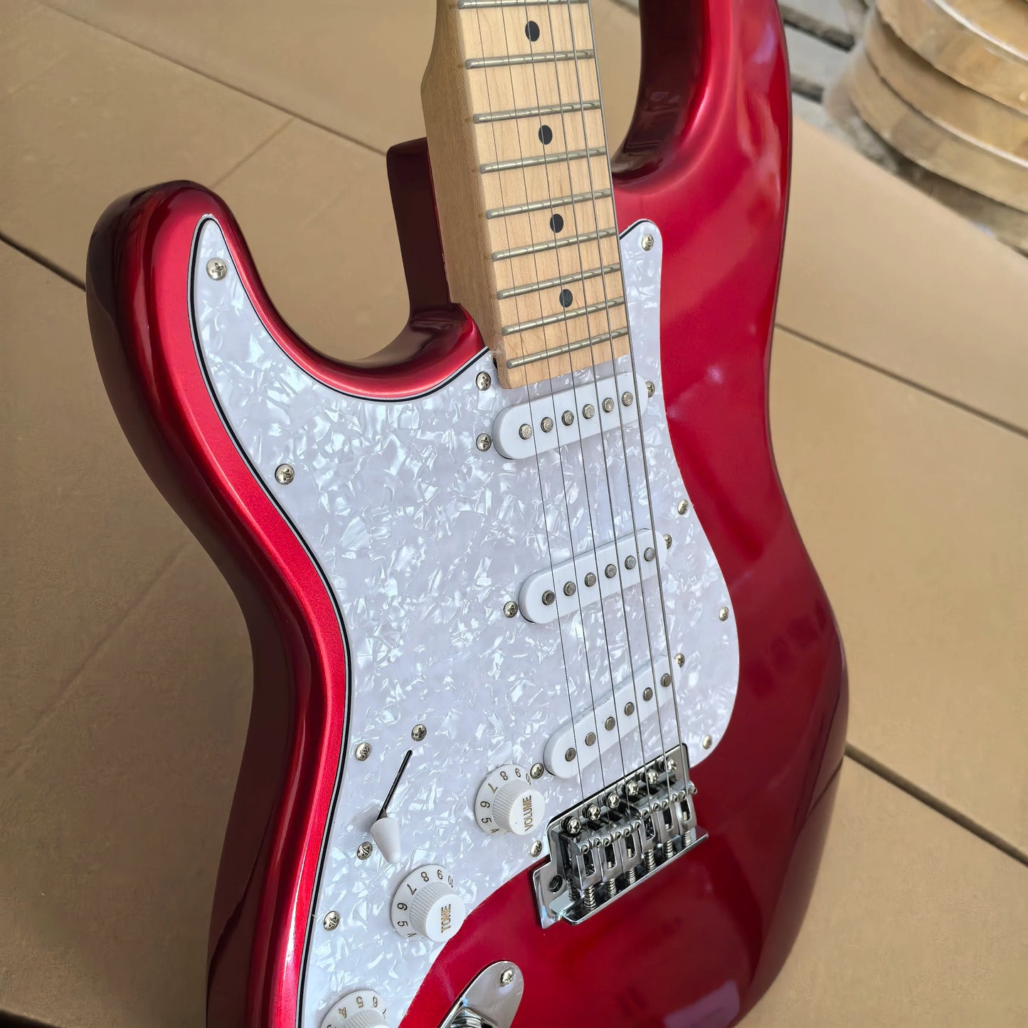 In stock, left-handed 6-string electric guitar in metallic red, made of mahogany with pearl pickguard. Ready to ship upon order!