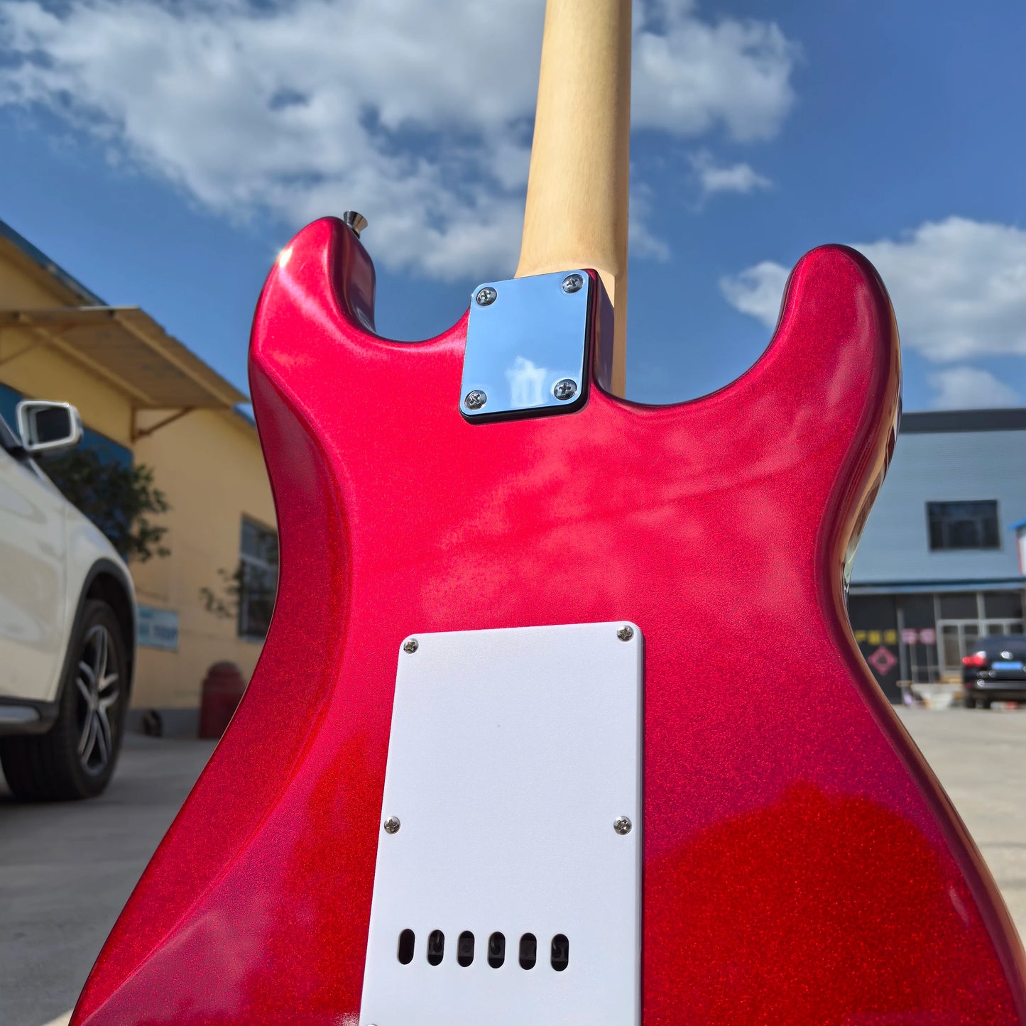 In stock, left-handed 6-string electric guitar in metallic red, made of mahogany with pearl pickguard. Ready to ship upon order!