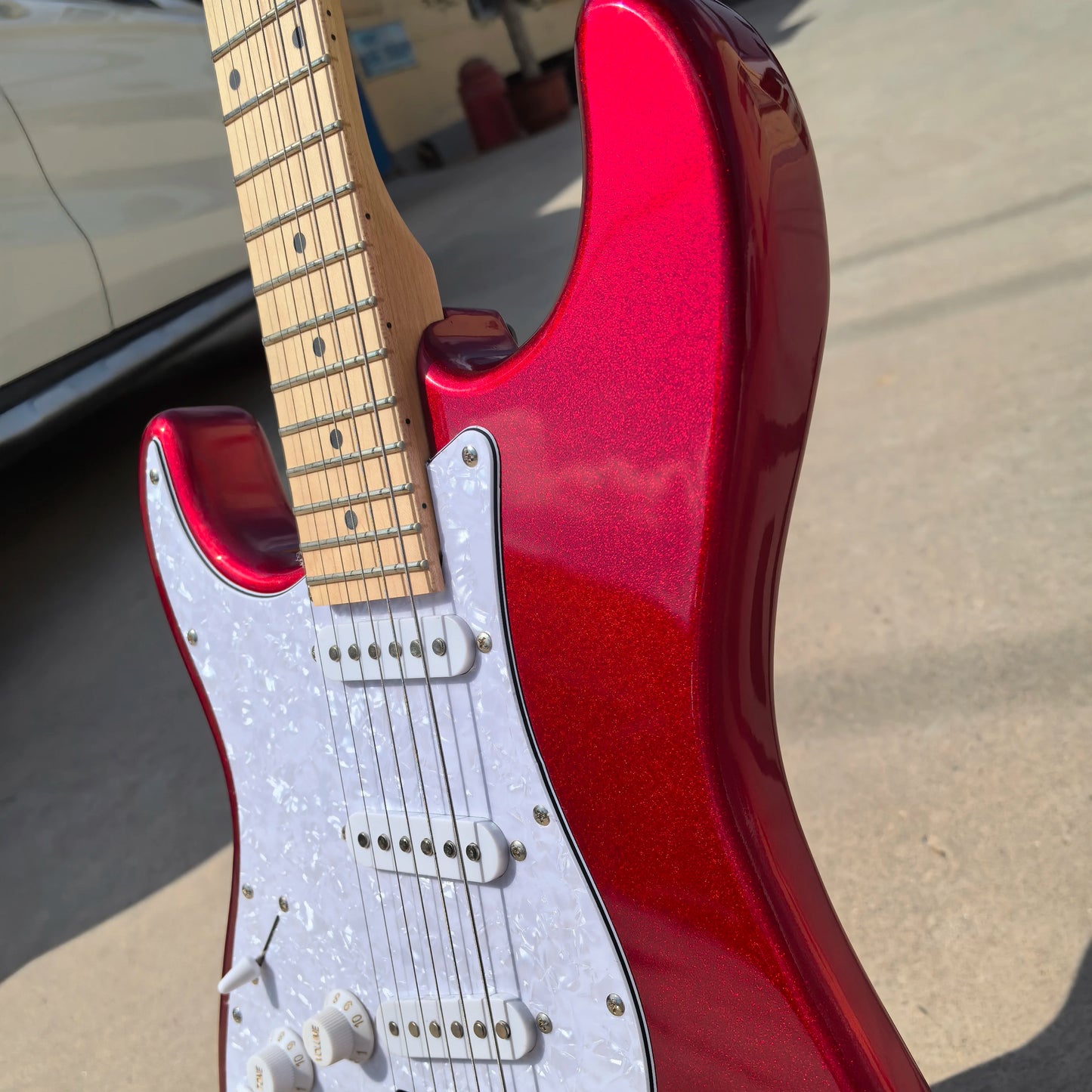 In stock, left-handed 6-string electric guitar in metallic red, made of mahogany with pearl pickguard. Ready to ship upon order!